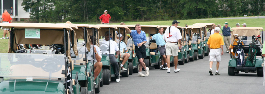 Golfers sitting and walking around carts