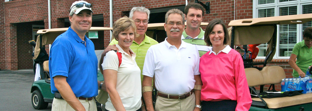 Golfers smiling by clubhouse